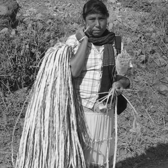 Mexican woman holding braided dried palm leaves working with Makaua